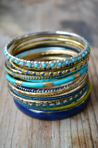 Beaux bracelets en or coûteux sur fond en bois — Photo