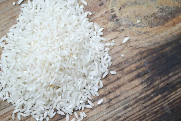 Arroz de grano largo sobre fondo madera — Foto de Stock