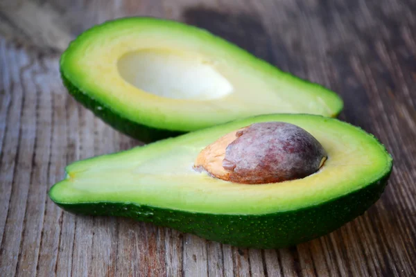 Ahşap masa üzerinde sağlıklı yeşil avokado