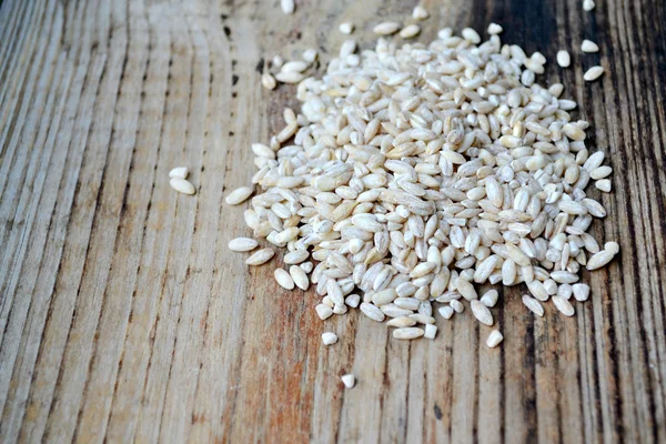 Жемчужное зерно ячменя на деревянном столе — стоковое фото