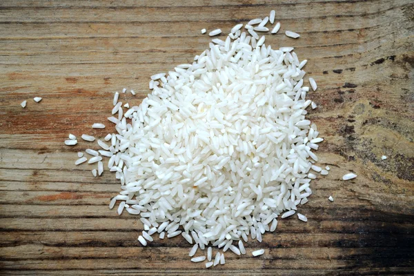 Langkorrelige rijst over houten achtergrond — Stockfoto
