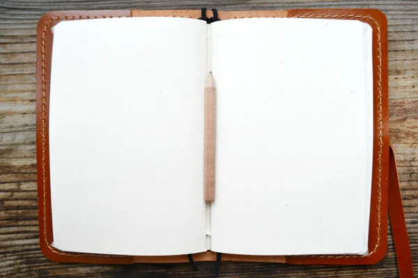 Um caderno retro vazio com papel velho, lápis pequeno e capa de couro — Fotografia de Stock