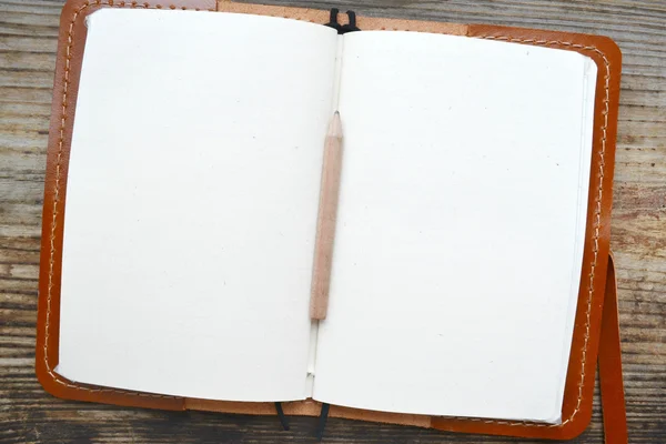 Un notebook retro gol cu hârtie veche, creion mic și capac din piele — Fotografie, imagine de stoc