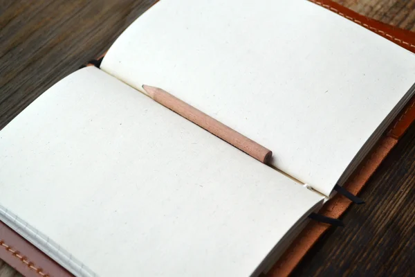 Ein leeres Retro-Notizbuch mit altem Papier, kleinem Bleistift und Ledereinband — Stockfoto