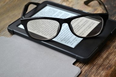 Ahşap masa retro gözlüklerle siyah ereader
