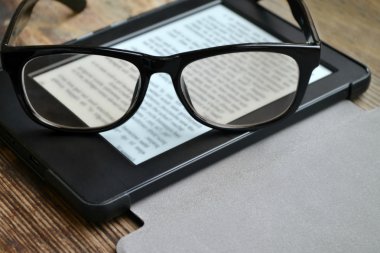 Ahşap masa retro gözlüklerle siyah ereader
