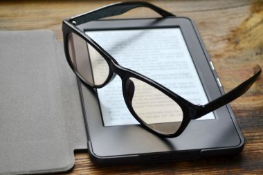 Ahşap masa retro gözlüklerle siyah ereader