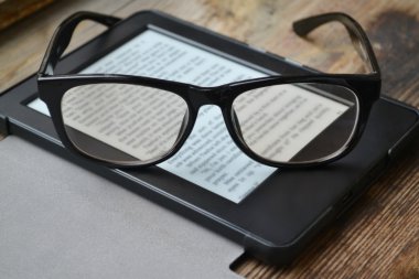 Ahşap masa retro gözlüklerle siyah ereader