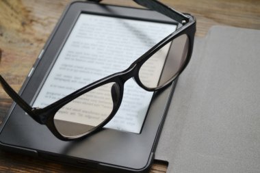 Ahşap masa retro gözlüklerle siyah ereader