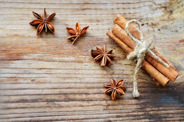 Varas de canela e estrelas de anis picantes na mesa de madeira — Fotografia de Stock