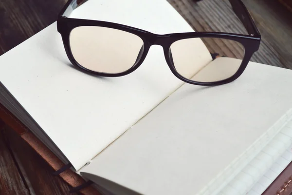 Ένα κενό σημειωματάριο ρετρό με παλιό χαρτί, γυαλιά και δερμάτινο κάλυμμα — Φωτογραφία Αρχείου