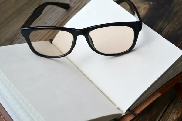 Eski kağıt, gözlük ve deri kapağı ile boş bir retro notebook — Stok fotoğraf