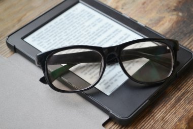 Ahşap masa retro gözlüklerle siyah ereader