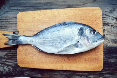 Pişmemiş dorado ahşap tahta üzerinde balık