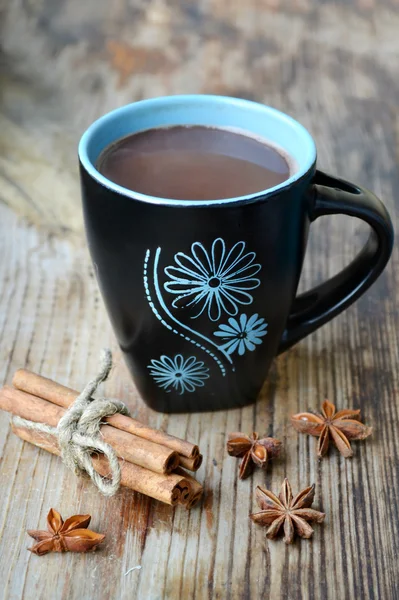 Taza negra y azul de cacao caliente con anís estrellado y canela — Foto de Stock