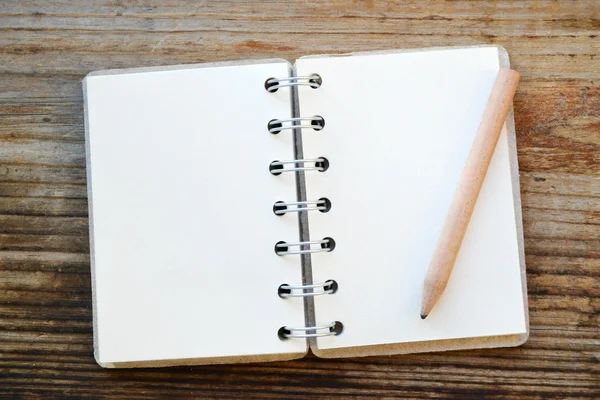 Um caderno retrô vazio com papel velho e lápis pequeno — Fotografia de Stock