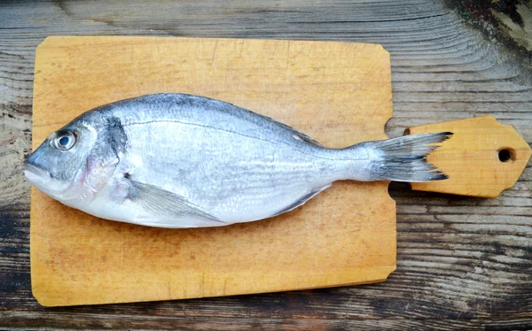 Pişmemiş dorado ahşap tahta üzerinde balık — Stok fotoğraf