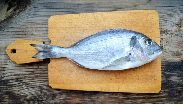 Pişmemiş dorado ahşap tahta üzerinde balık — Stok fotoğraf
