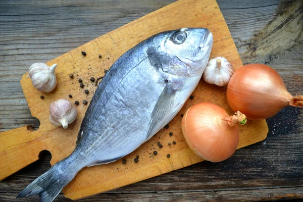 Pişmemiş dorado balık sarımsak ve soğan ile — Stok fotoğraf