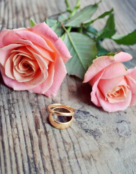 Dois anéis dourados de noivado em um lindo buquê de casamento de rosas rosa — Fotografia de Stock