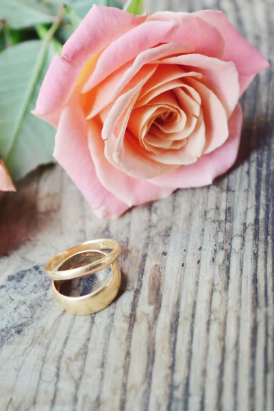Два обручальных золотых кольца на красивом свадебном букете розовых роз — стоковое фото