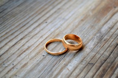 Ahşap masa üzerinde iki altın nişan yüzük