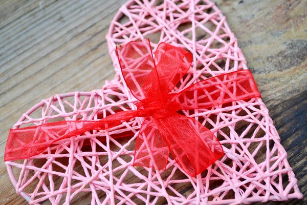 Pink handmade heart with red ribbon bow for St Valentine 's Day — стоковое фото