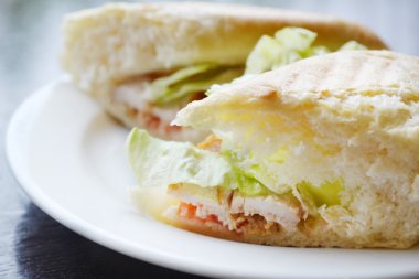 Marul ve beyaz tabakta tavuk ile iki büyük sandviç