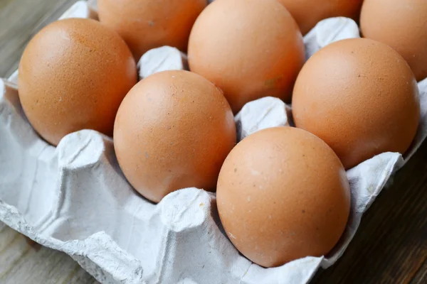 Braune Eier im Korb auf Holztisch — Stockfoto