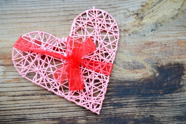 Rosa handgjorda hjärta med röda band rosett för St Alla hjärtans dag — Stockfoto