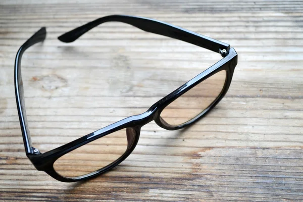 Black vintage reading glasses for computer on wooden table — Stock Photo, Image