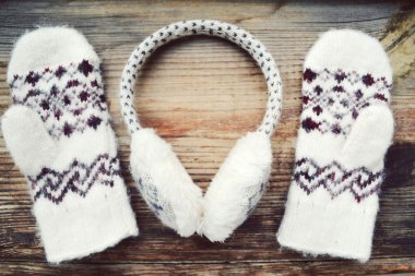 Ahşap masa üzerinde kış kulaklıklarla yumuşak yünlü eldivenler