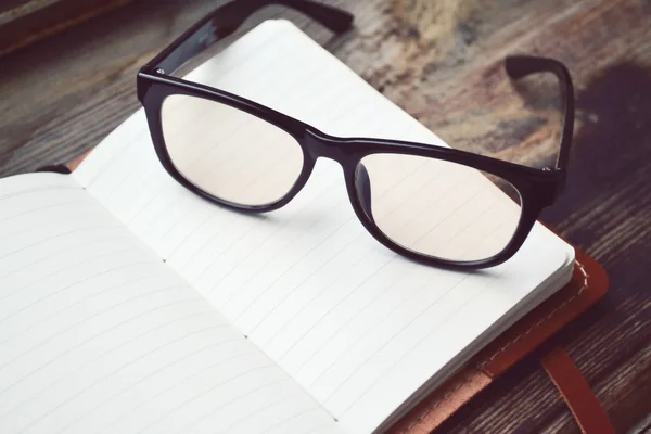 Ein leeres Retro-Notizbuch mit altem Papier, Brille und Ledereinband — Stockfoto