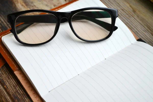 Ein leeres Retro-Notizbuch mit altem Papier, Brille und Ledereinband — Stockfoto