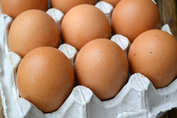 Braune Eier im Korb auf Holztisch — Stockfoto