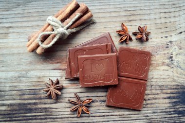 Yıldız sanagüzel ve ahşap masa üzerinde tarçın ile sütlü çikolata parçası