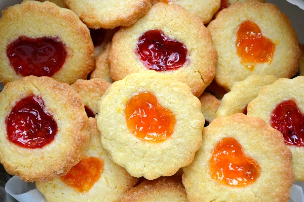 Hausgemachte Plätzchen mit herzförmiger Marmelade auf Holztisch — Stockfoto