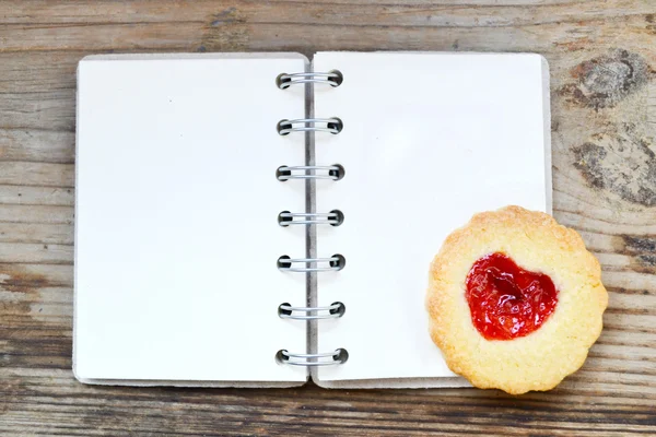 自制饼干心形果酱和木制的桌子上的空复古螺旋食谱书 — 图库照片