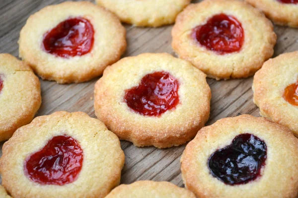 Galletas caseras con mermelada en forma de corazón en mesa de madera — Foto de Stock