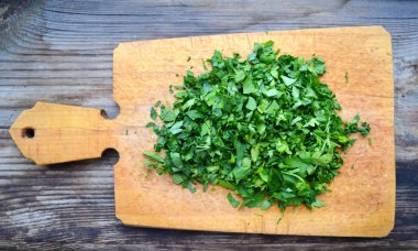 Ahşap tahta üzerinde kıyılmış taze yeşil maydanoz