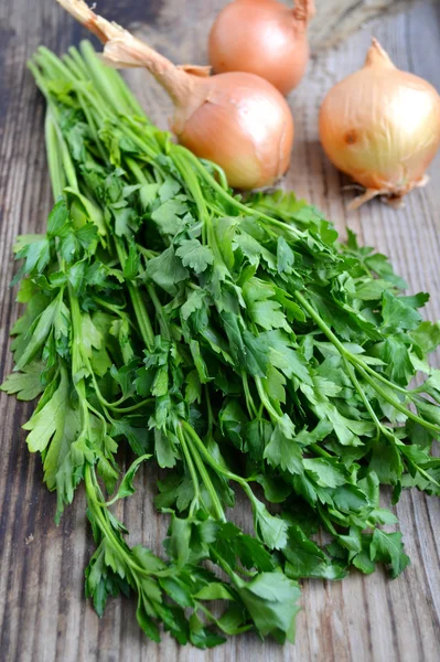 Bunch of fresh green parsley with onions on wooden table — Stock Photo, Image