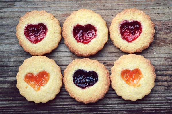 Homemade cookies with heart shaped jam on wooden table — Stock Photo, Image