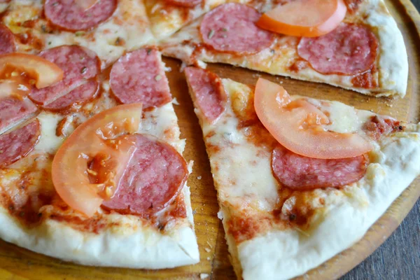 Grote hete pizza met tomaten en salami — Stockfoto
