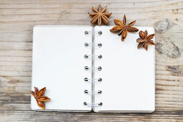 Een lege retro spiraal notebook met oud papier en anijs sterren op houten tafel — Stockfoto