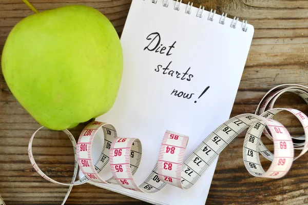Konsep diet dengan apel hijau, notebook dan pita pengukur pada meja kayu — Stok Foto