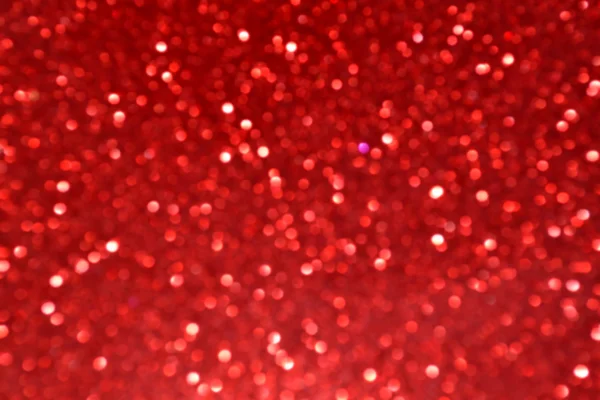 Fond rouge flou lumineux et abstrait avec des paillettes chatoyantes — Photo