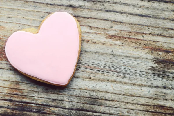 Άρτος αρωματισμένος με τζίντζερ σε σχήμα καρδιά με ροζ κερασάκι στην ξύλινο τραπέζι — Φωτογραφία Αρχείου
