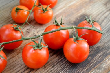 Ahşap masa üzerinde küçük kırmızı kiraz domates demet