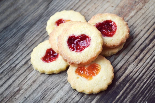 Homemade cookies with heart shaped jam on wooden table — Stock Photo, Image