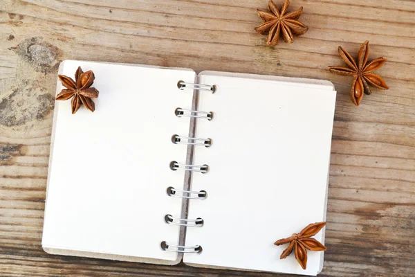 Um caderno espiral retro vazio com papel velho e estrelas de anis na mesa de madeira — Fotografia de Stock